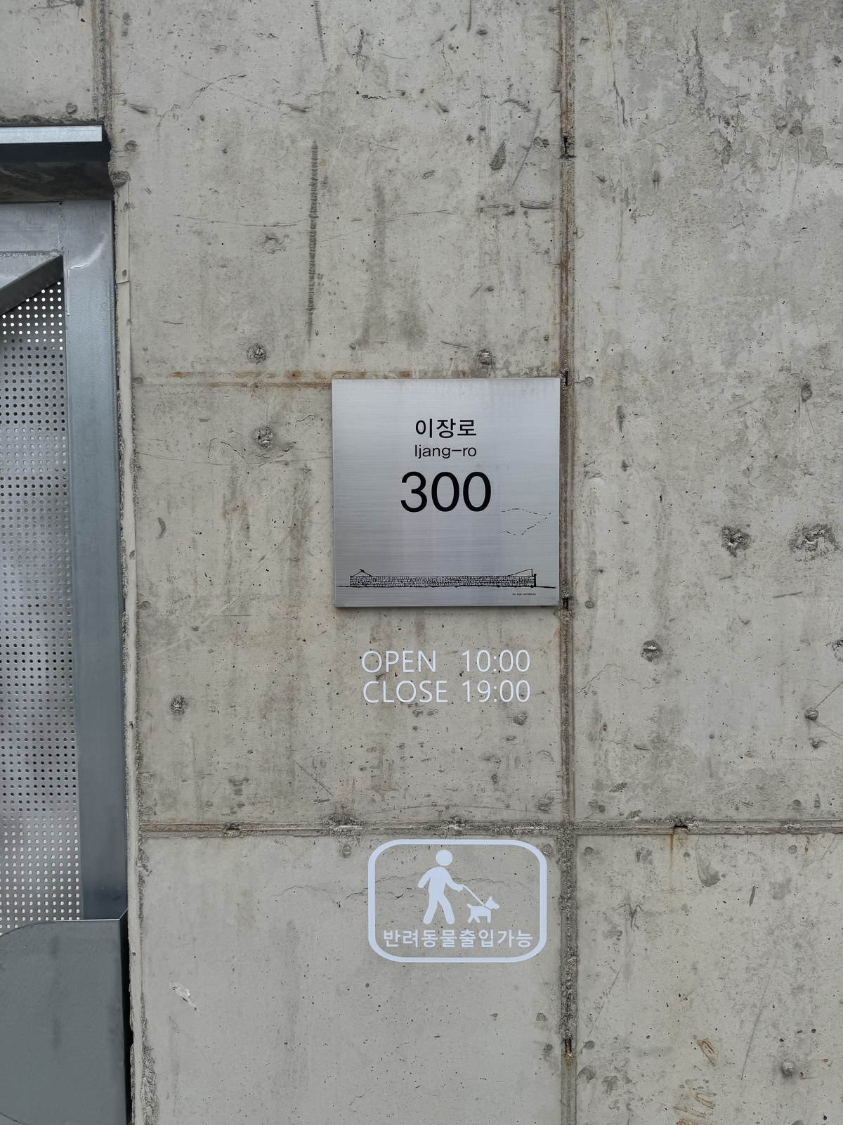 콘크리트 벽에 붙은 이장로 300 명판과 반려동물 동반 가능 표시