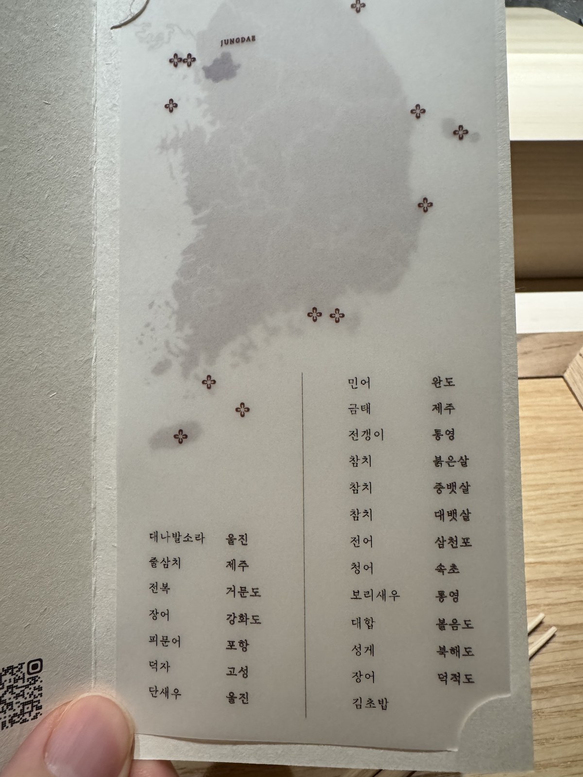 그날 들어온 생선과 산지를 적은 종이가 손에 들린 장면