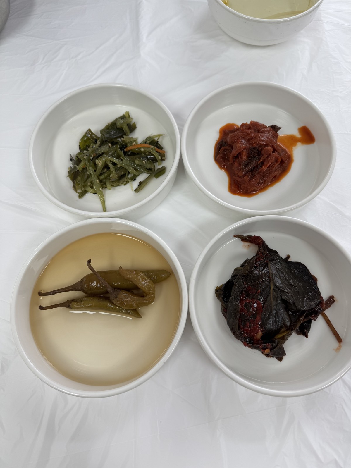 효제 반찬 네 가지 — 고추절임, 미역무침, 깻잎장아찌, 볶음김치