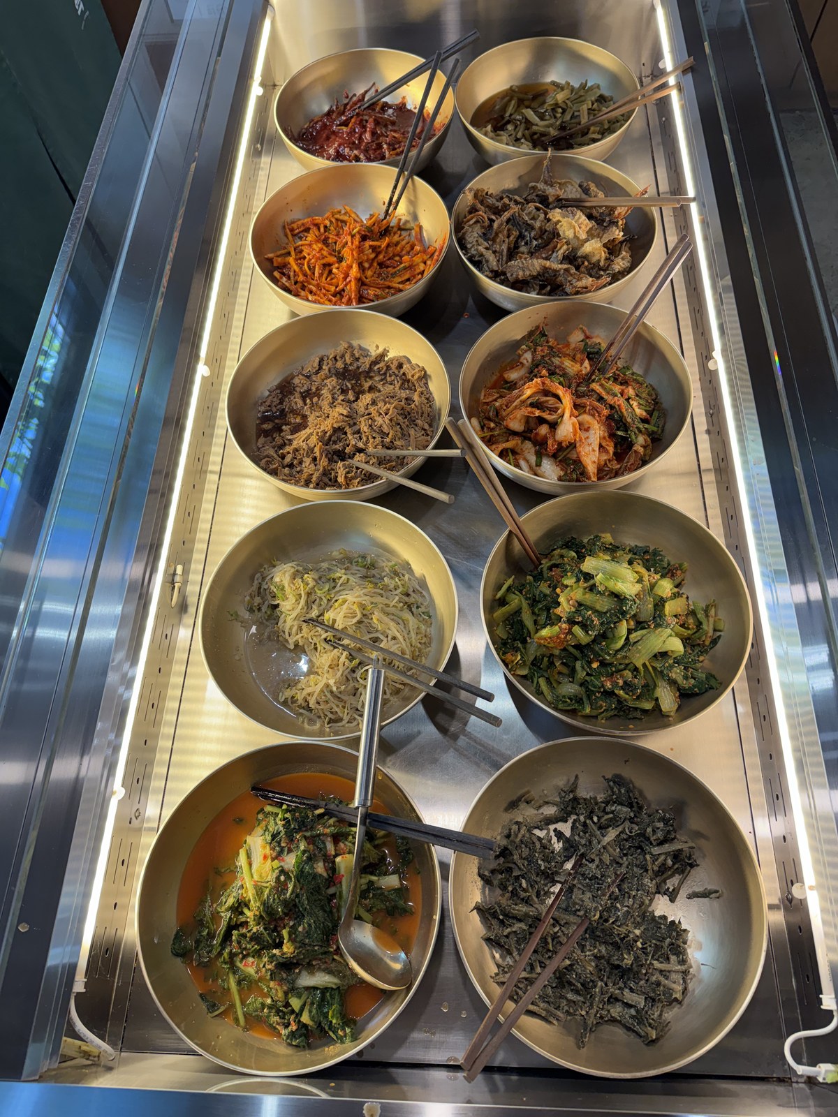 일호점미역 셀프 반찬바 — 나물과 장아찌가 통마다 담겨 있다