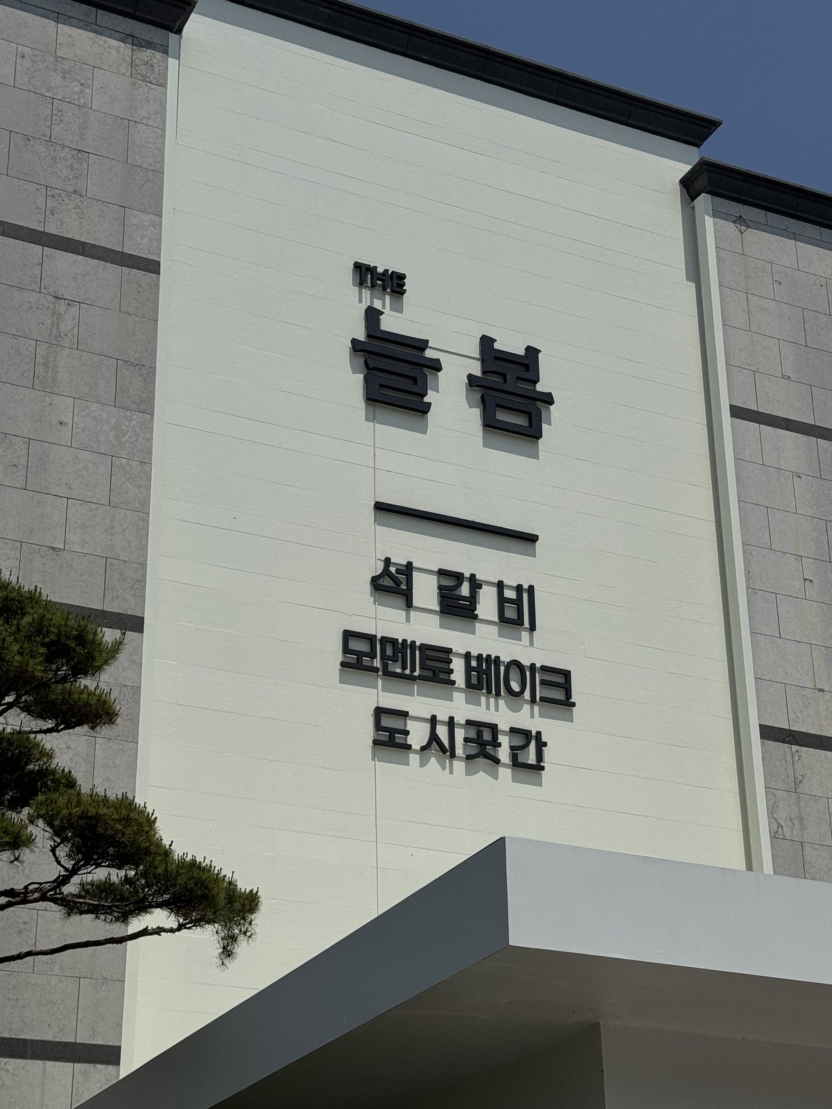 건물 외벽에 적힌 THE 늘봄 석갈비와 모멘토베이크 간판